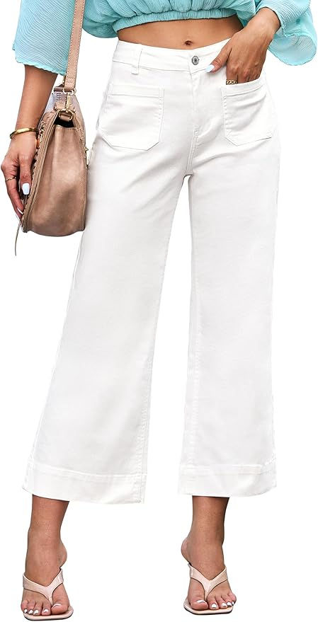 Woman in white wide-leg pants and light blue top, holding a beige bag. She's wearing heeled sandals. Background is plain white.