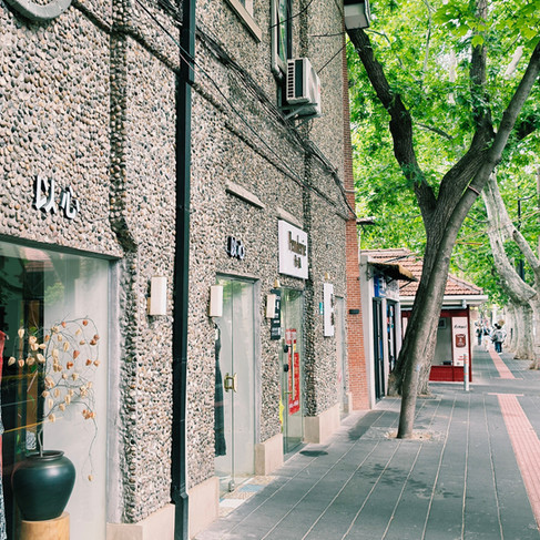 Grey building with storefronts that have Chinese letters on top