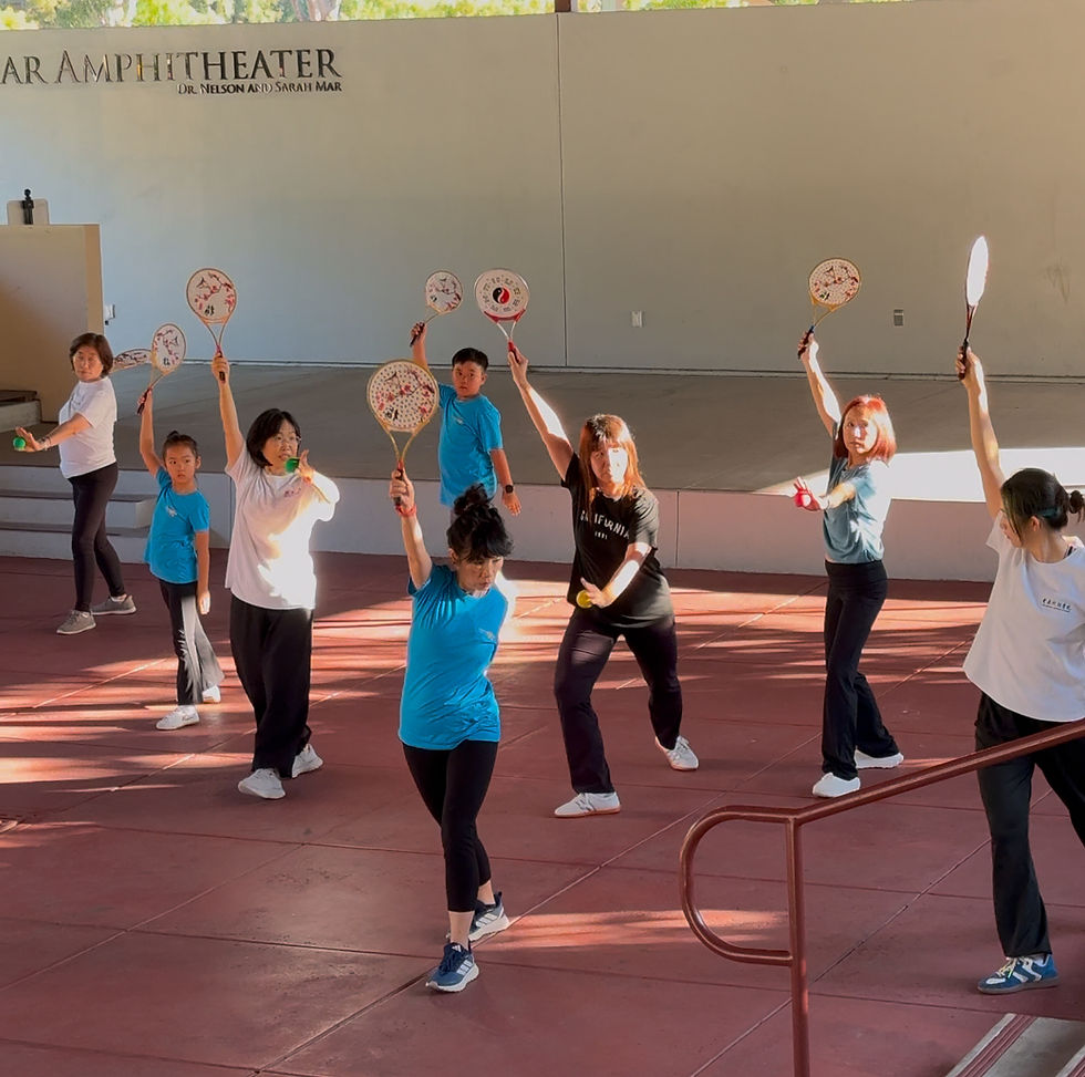 A professional instructor guiding students through dynamic Flowball sequences under the sun for shoulder and neck mobility.