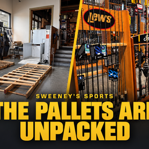 Empty pallets beside fully stocked fishing rod and reel displays at Sweeney’s Sports, with yellow text reading “The Pallets Are Unpacked.”
