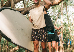 surfer walking with board through the trail to la lancha beach nayarit