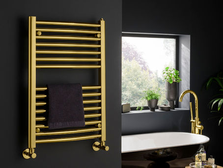 A gold chrome towel rail in a dark grey bathroom