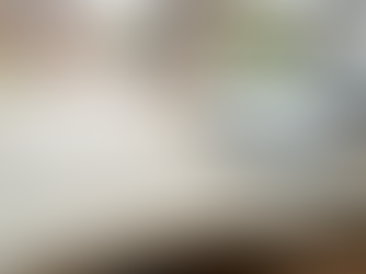 Hand-drawn three-column strategy plan open in a notebook on a desk, laptop and residential window softly blurred behind