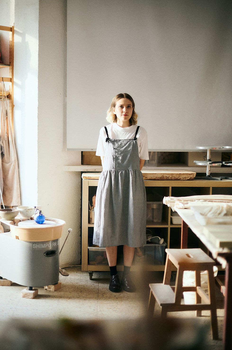 Woman in apron standing in a pottery studio
