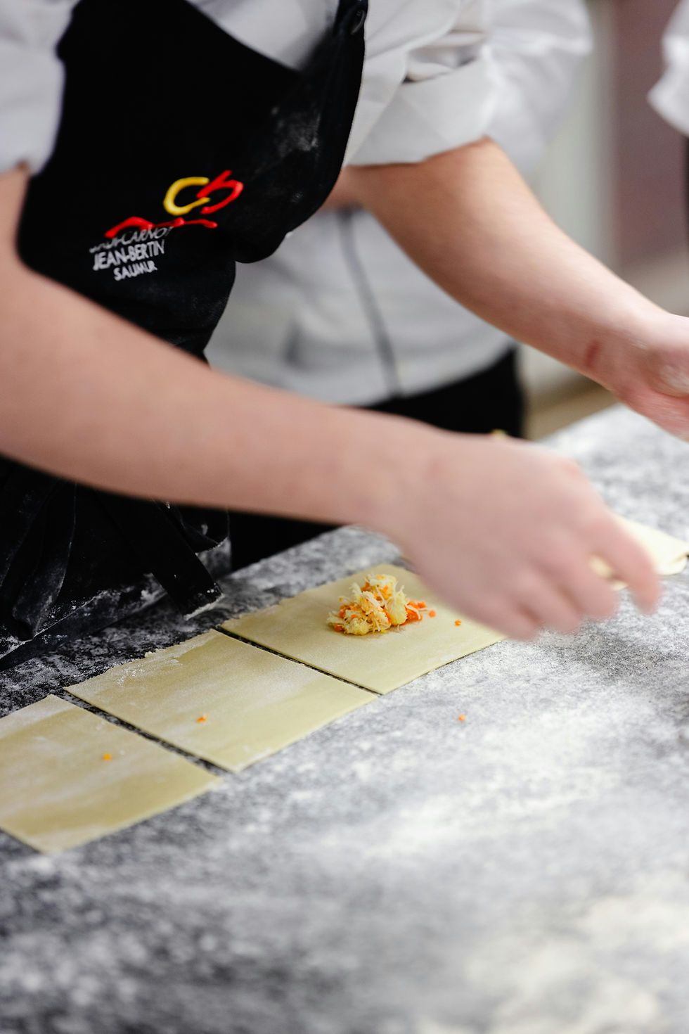 Chef preparing ravioli pasta with filling on a floured surface. Fine Dining