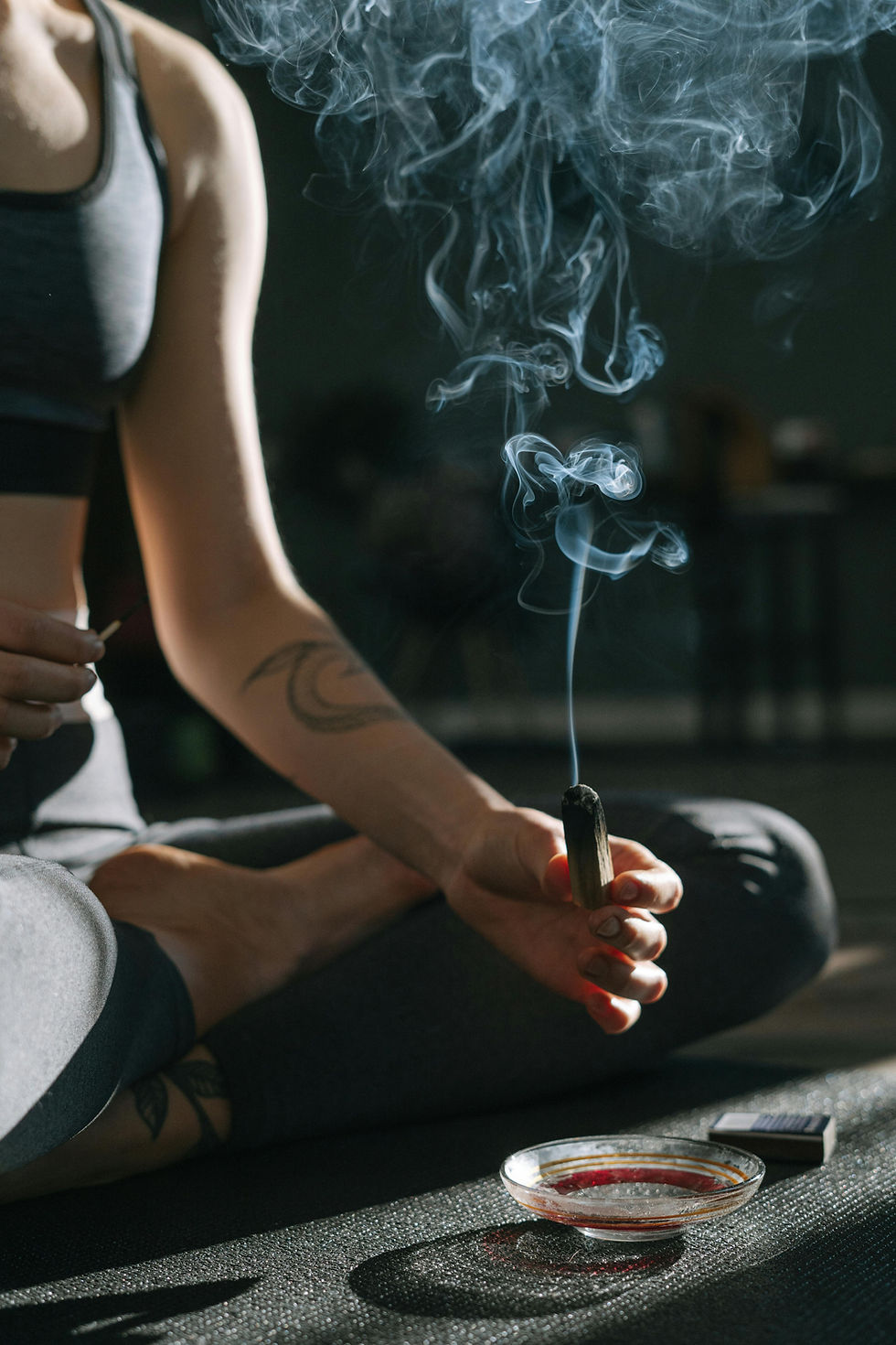 Woman meditating with incense at Calido Yoga