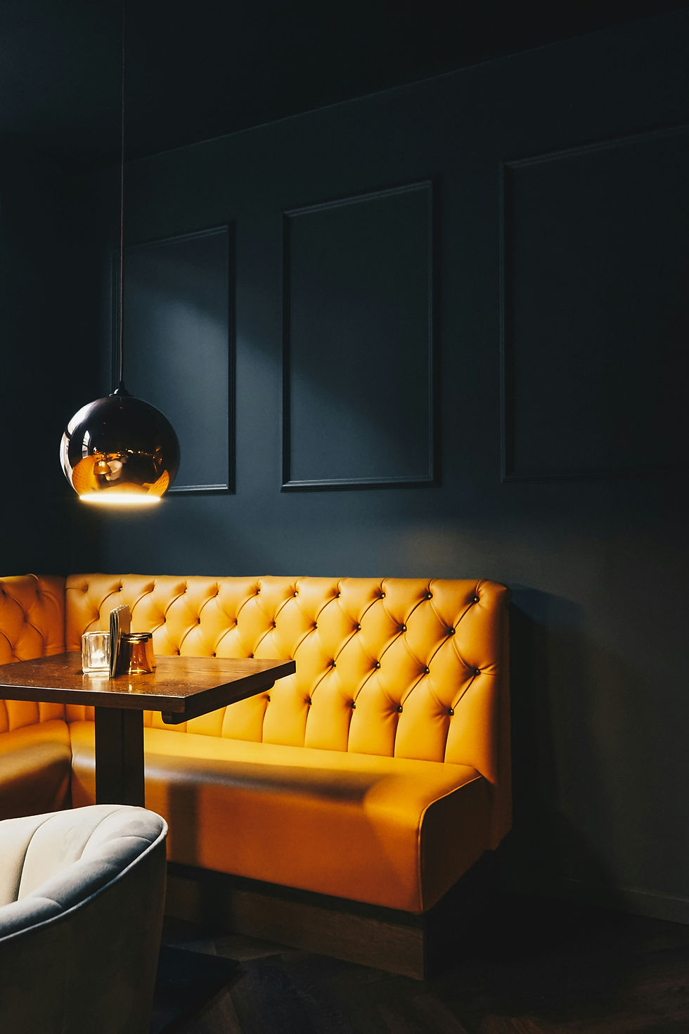Oranje bank en lamp in donker restaurantinterieur