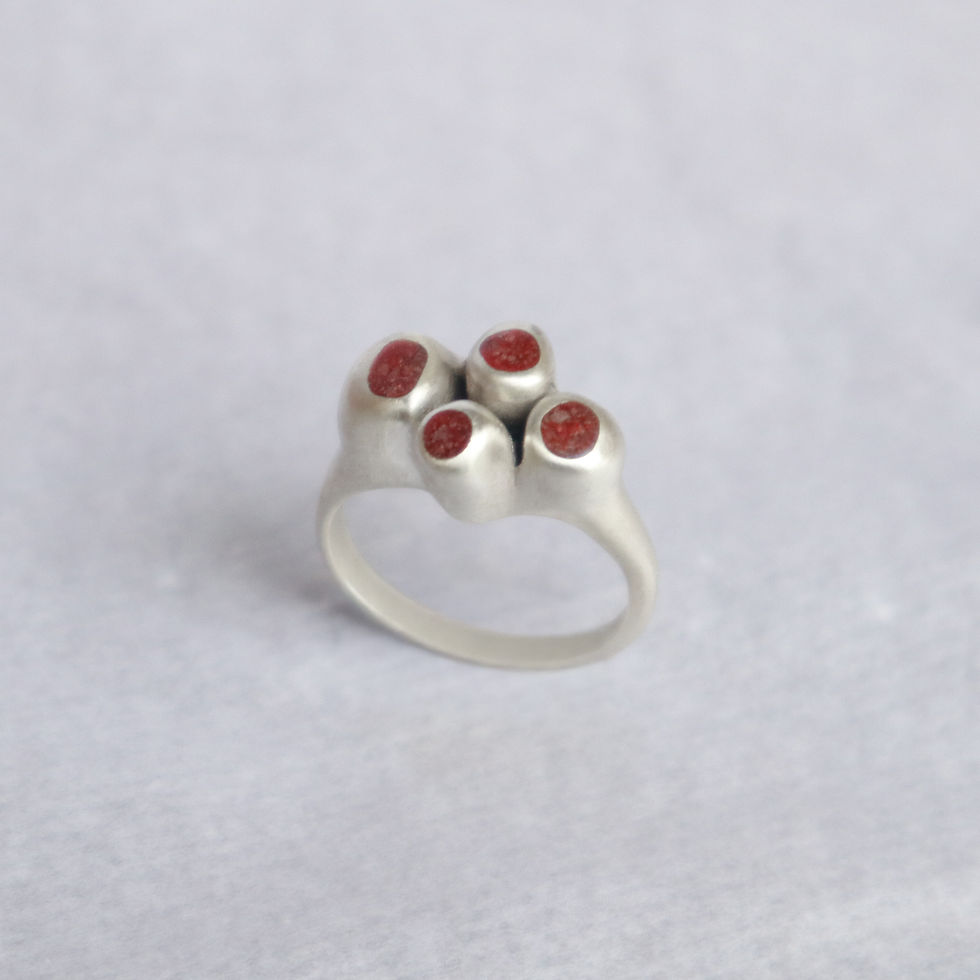 Anel em prata 950 fosca com inlay de areia vermelha.