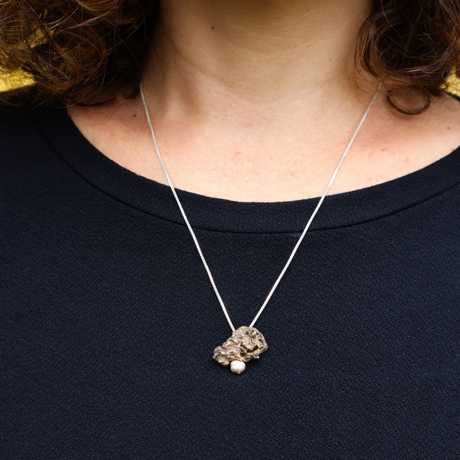 Pingente em latão com pérola de água doce.