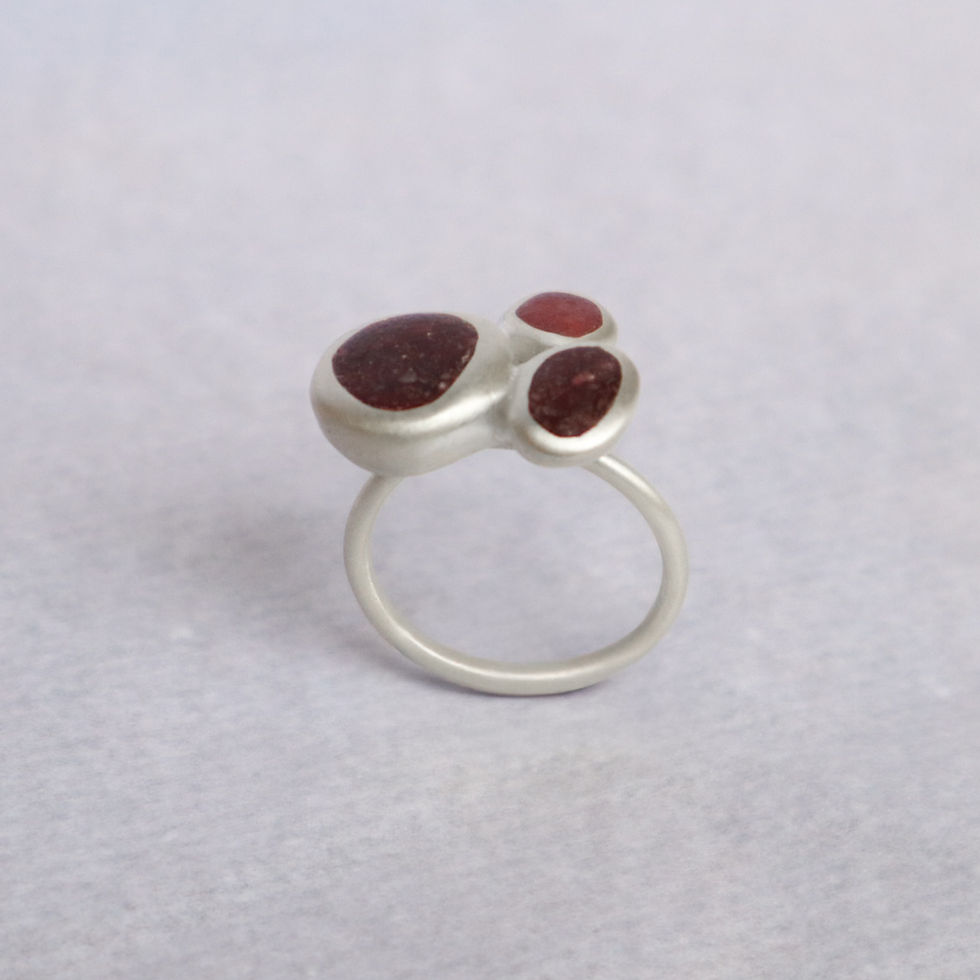 Anel em prata 950 fosca com inlay de areia vermelha.
