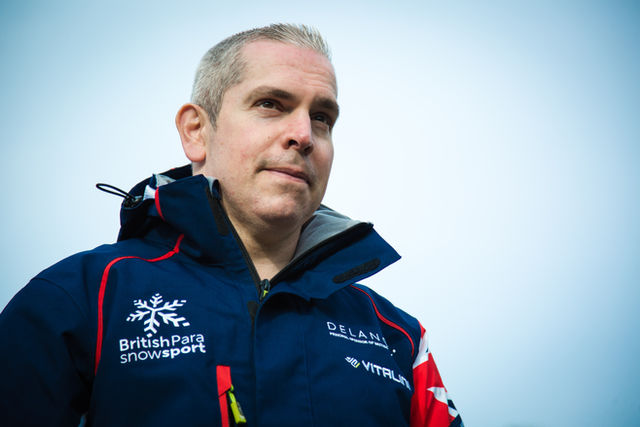 A man wearing a ski jack looking into the distance 