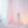 Gentle scene: vintage microphone, pink drapes, lit candle.