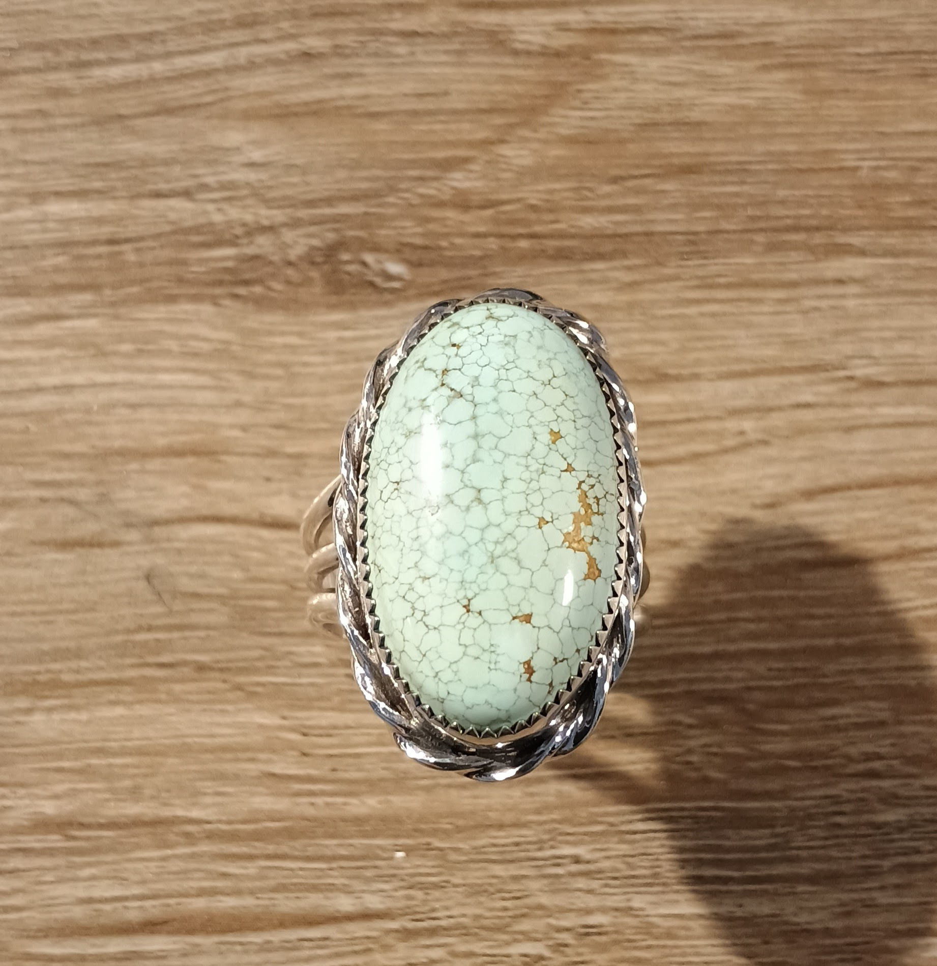 Top-down view of a large oval robin's egg blue Number 8 turquoise ring with a fine spiderweb matrix, set in sterling silver.