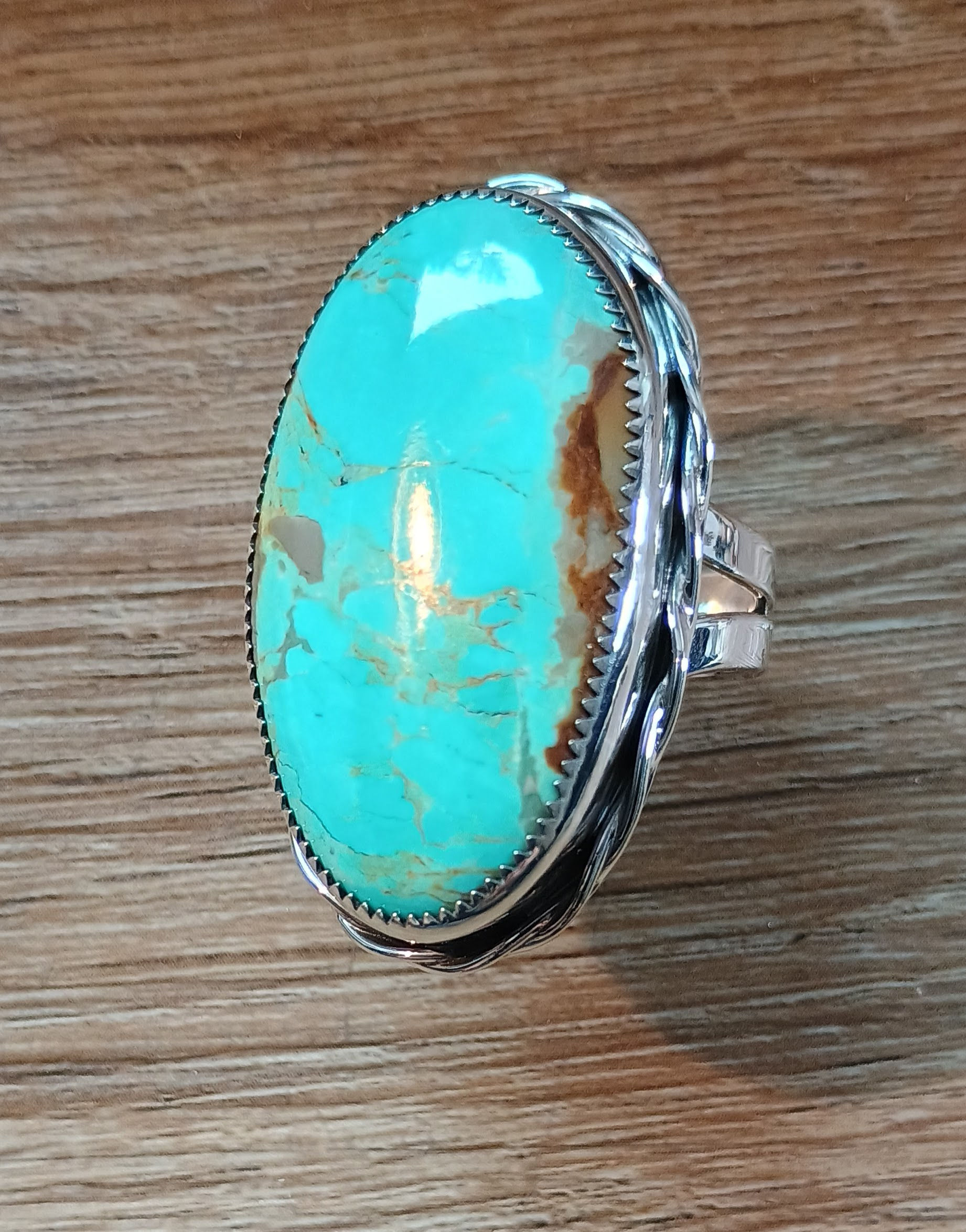 High-grade 36x21mm oval turquoise statement ring in sterling silver bezel setting.