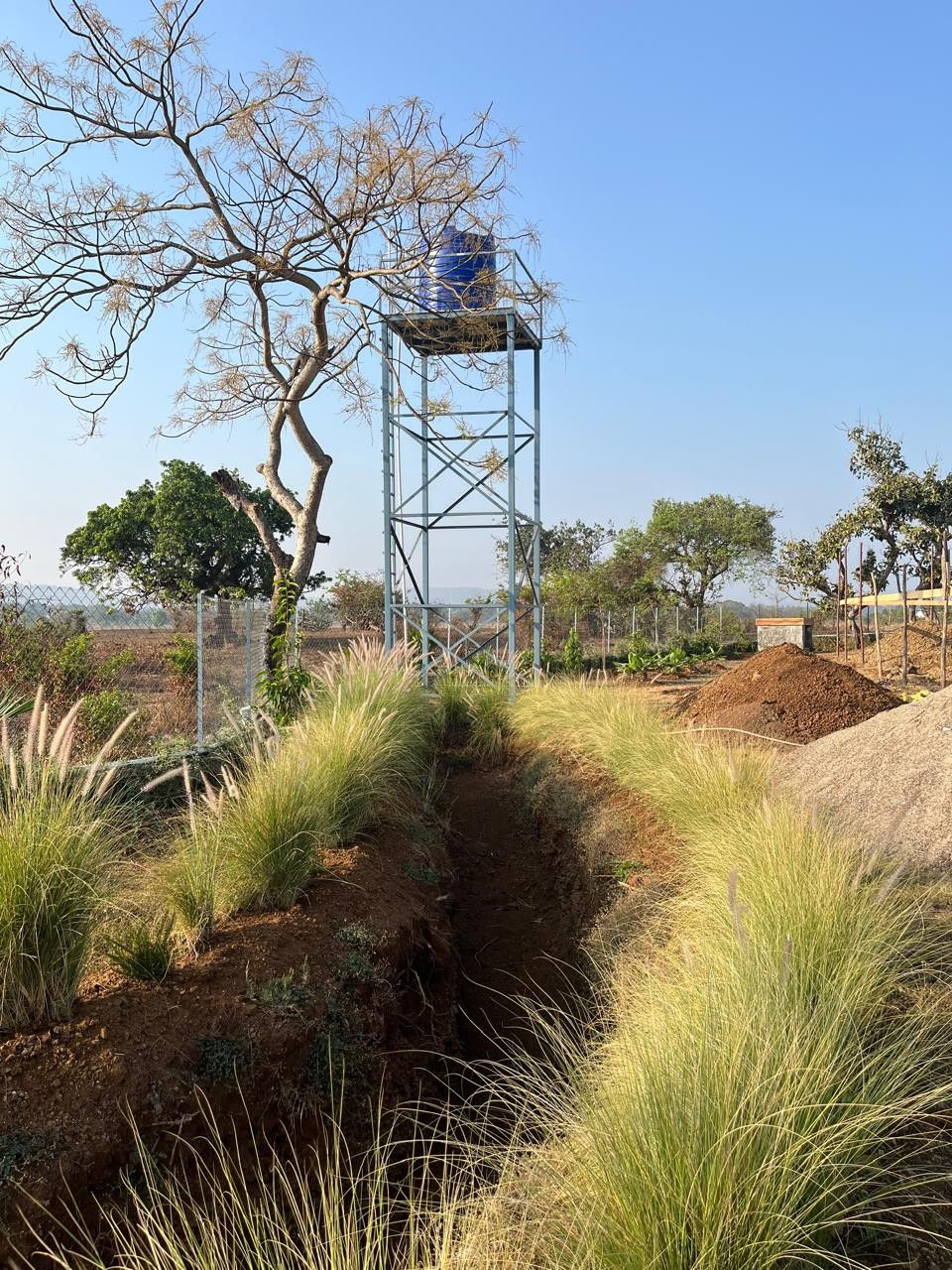 A model solar powered water pump that fills this borewell water tank on a tower on site