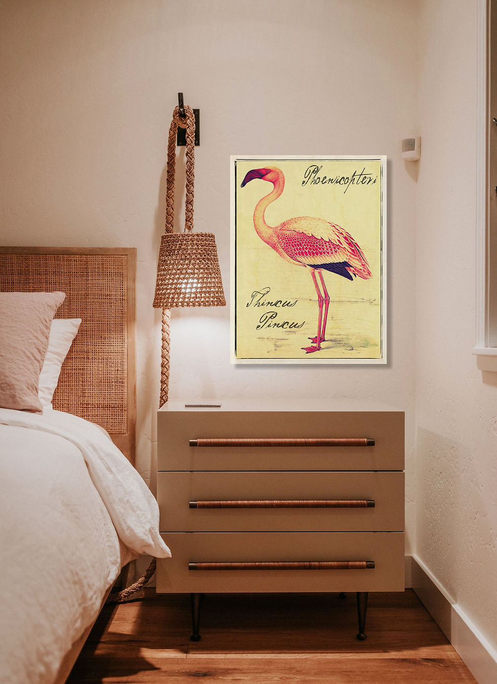 Cozy bedroom with a wicker lamp and a dresser. A flamingo vintage botanical art illustration with text hangs on the wall. Warm lighting creates a calm mood.