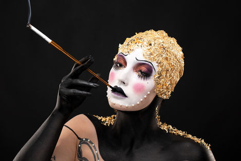 Travail d'un élève de Stéphanie Bernard, maquillage doré théâtral avec masque partiel et contraste noir et or