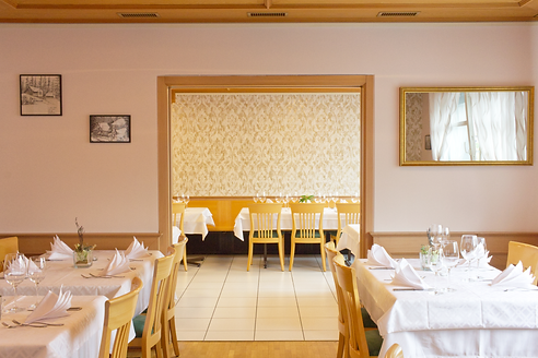 Wand- und Farbgestaltung mit Tapete, schwarz-weiss Bilder und goldiger Spiegel im Restaurant Adler in Kägiswil