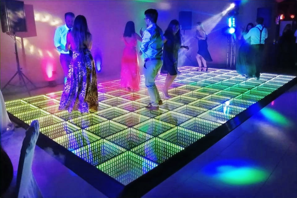 Eye-level view of a couple dancing on a glowing LED dance floor