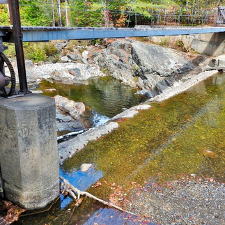 Dam facing northwest from atop intake bay, outlet gate on left.