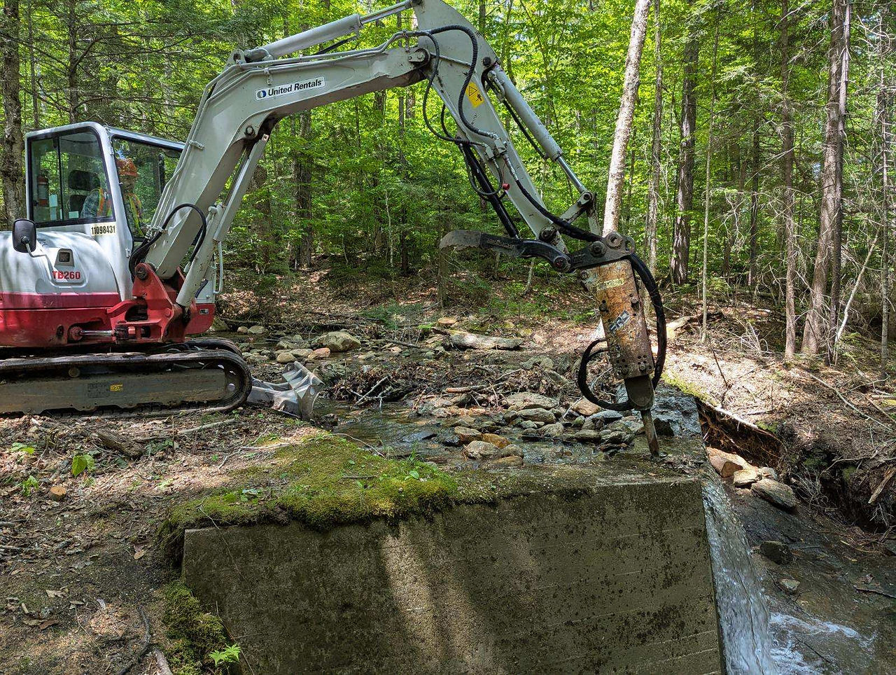 Drilling machinery in the process of breaking up a concrete dam