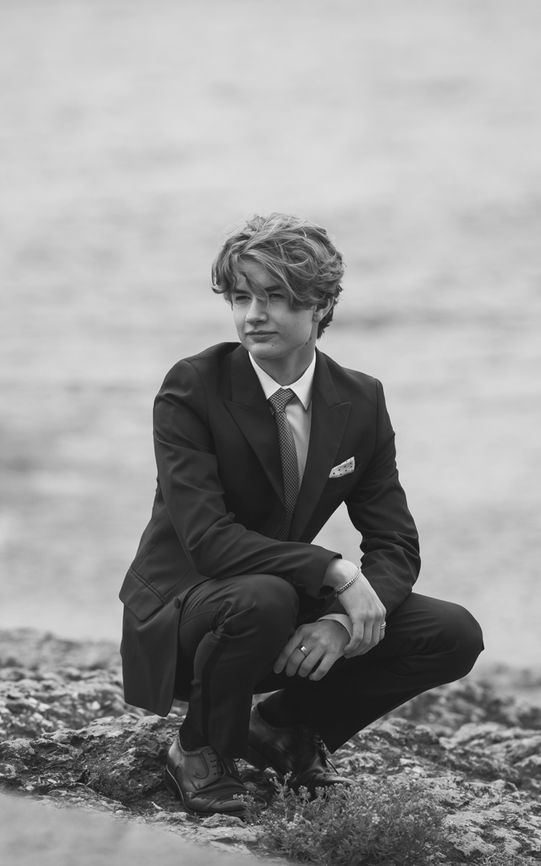 Naturlig portrett av konfirmant i dress fotografert nær sjøeni Oslo