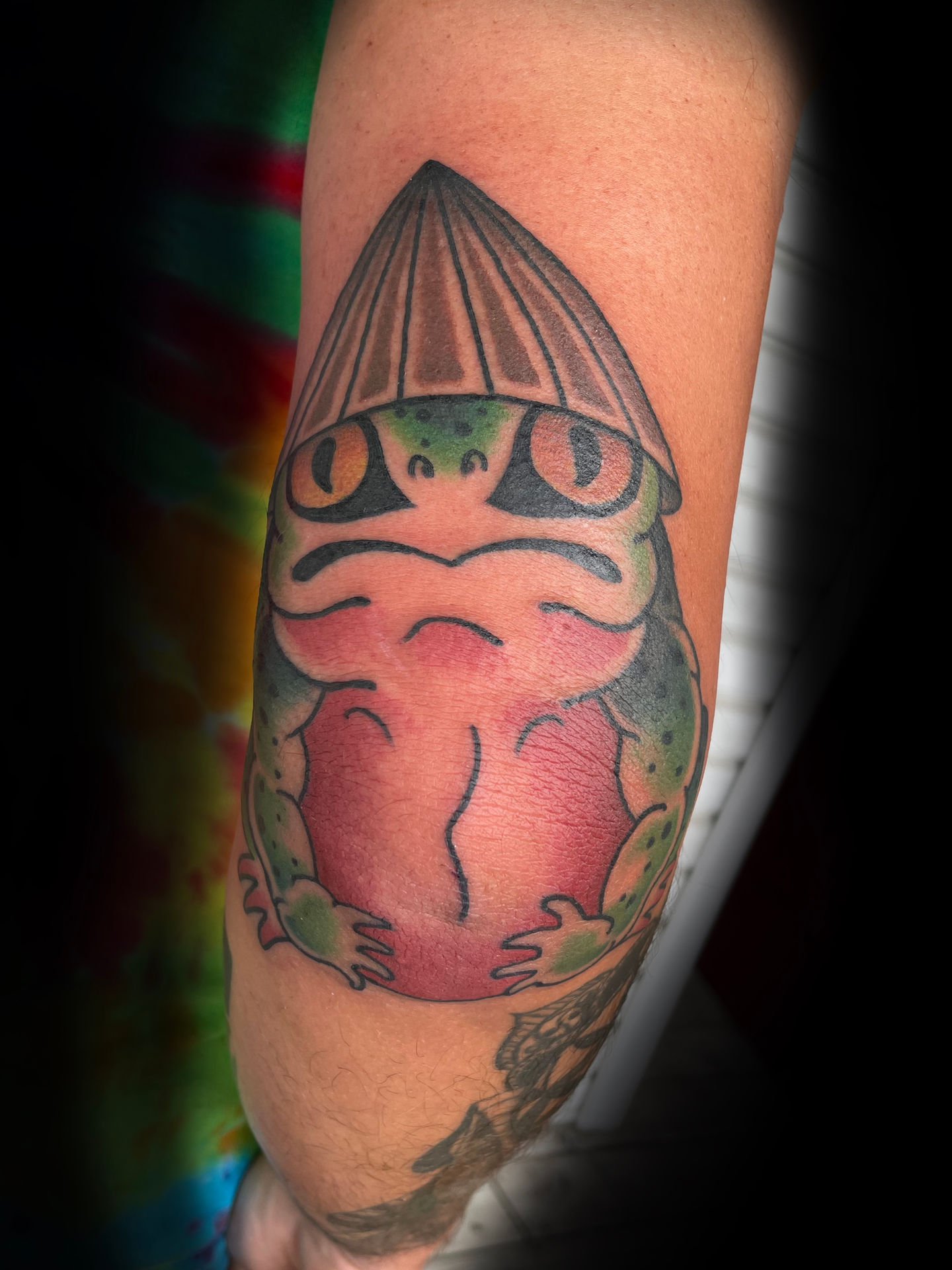 a tattoo of a frog with a hat on its head
