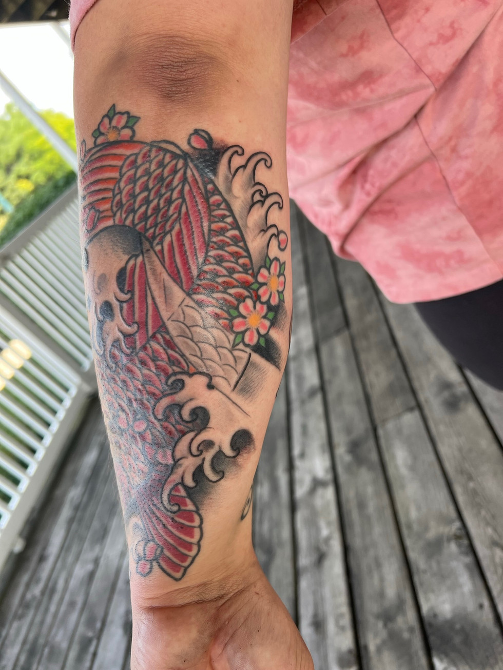 a person has a tattoo of a fish on their arm