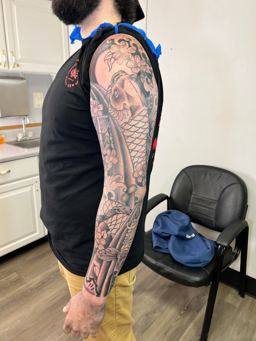 a man with a tattoo of a fish on his arm