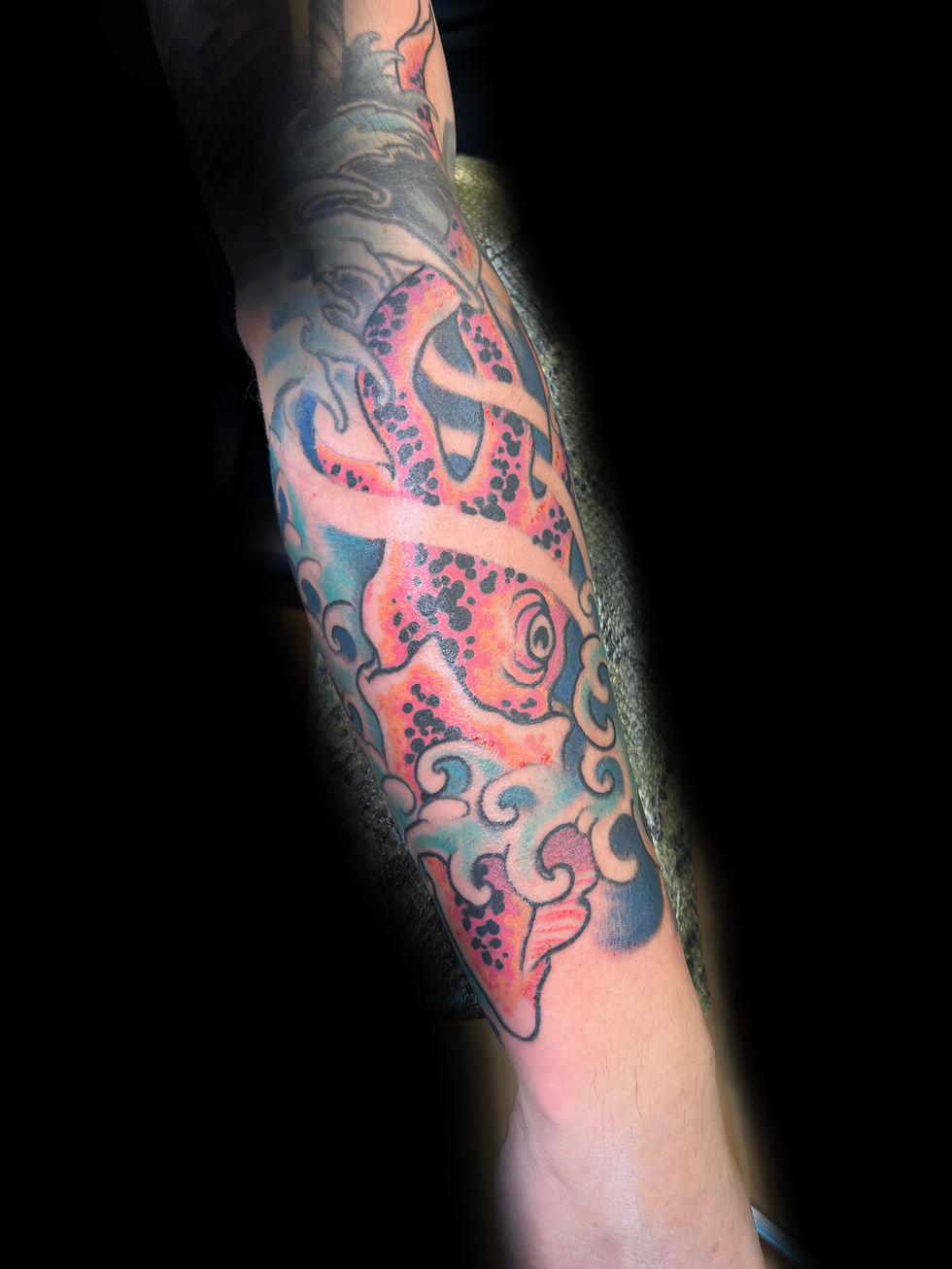 a person has a tattoo of an octopus on their arm