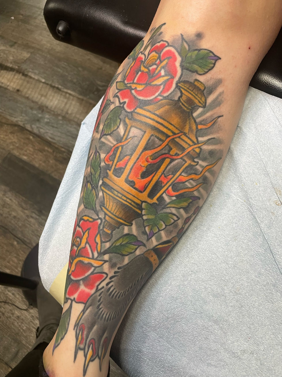 a tattoo of a lantern with flames and roses