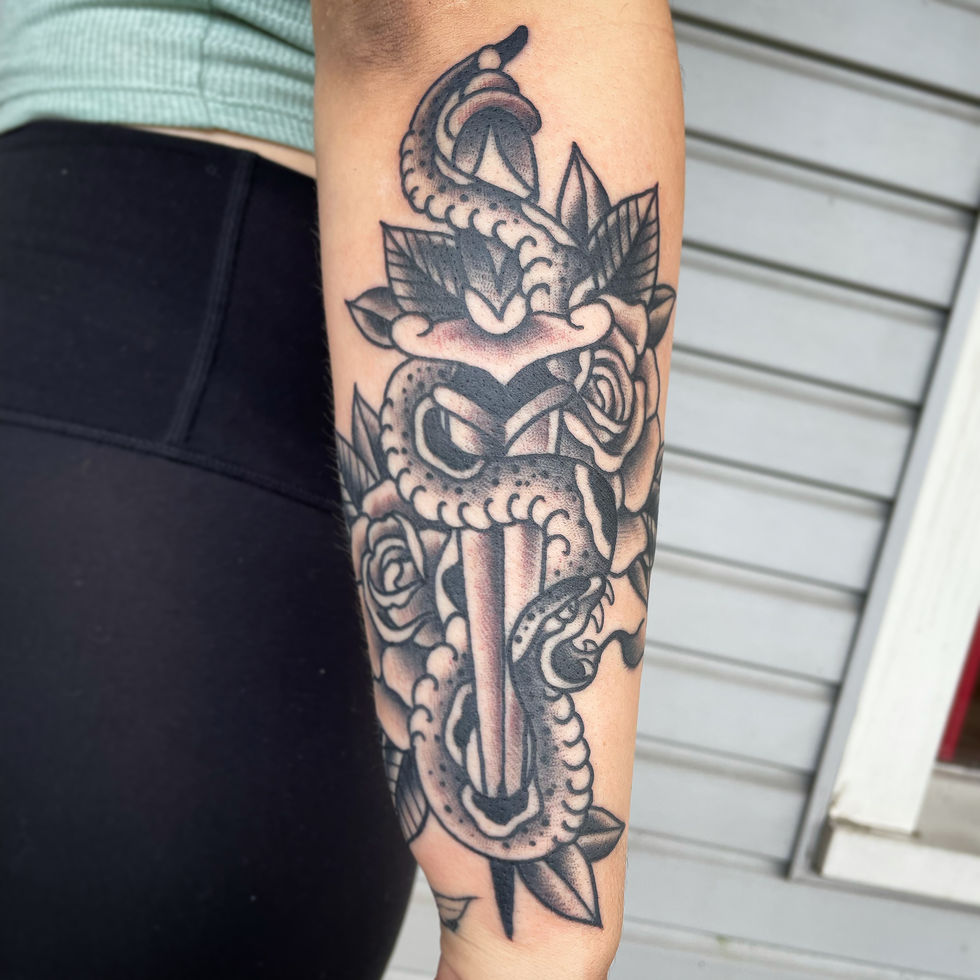 a woman has a tattoo of a dagger with a snake wrapped around it