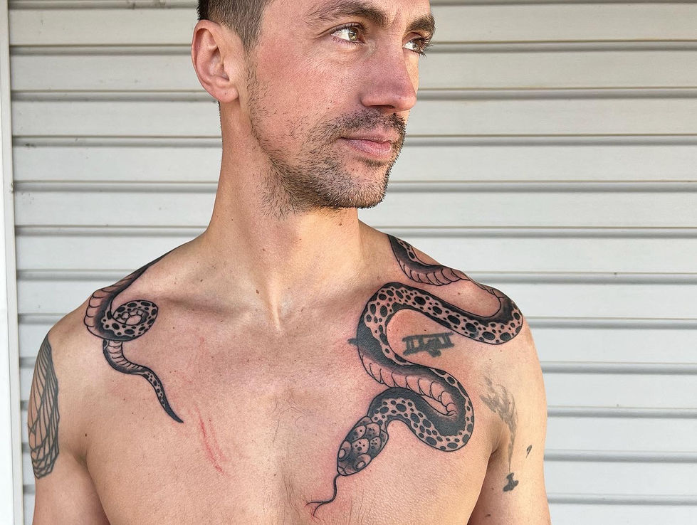 a man has a snake tattoo on his chest and shoulder