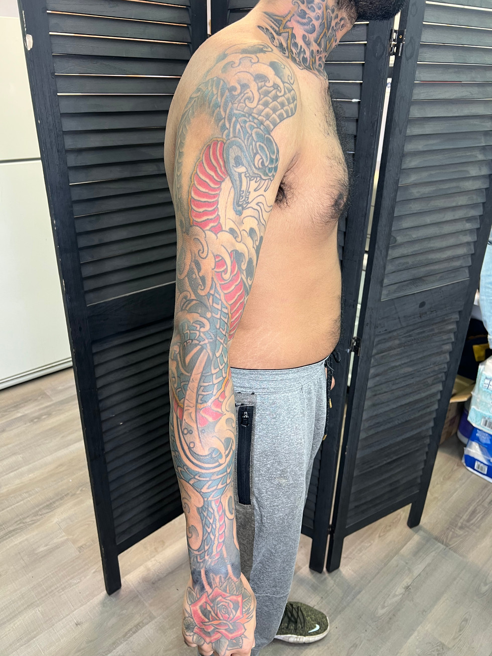 a man has a tattoo of a snake on his arm
