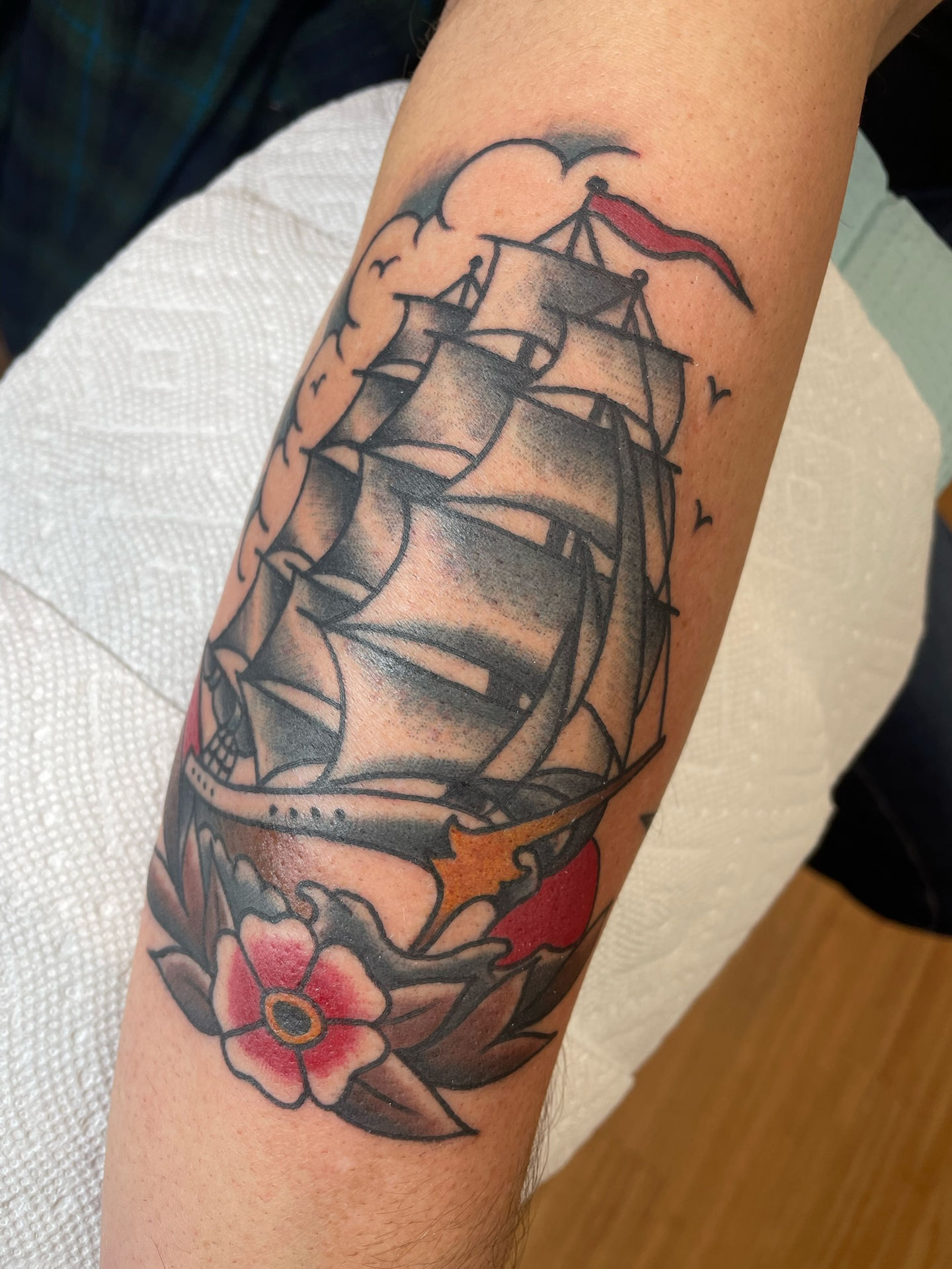 a tattoo of a ship on a person 's arm