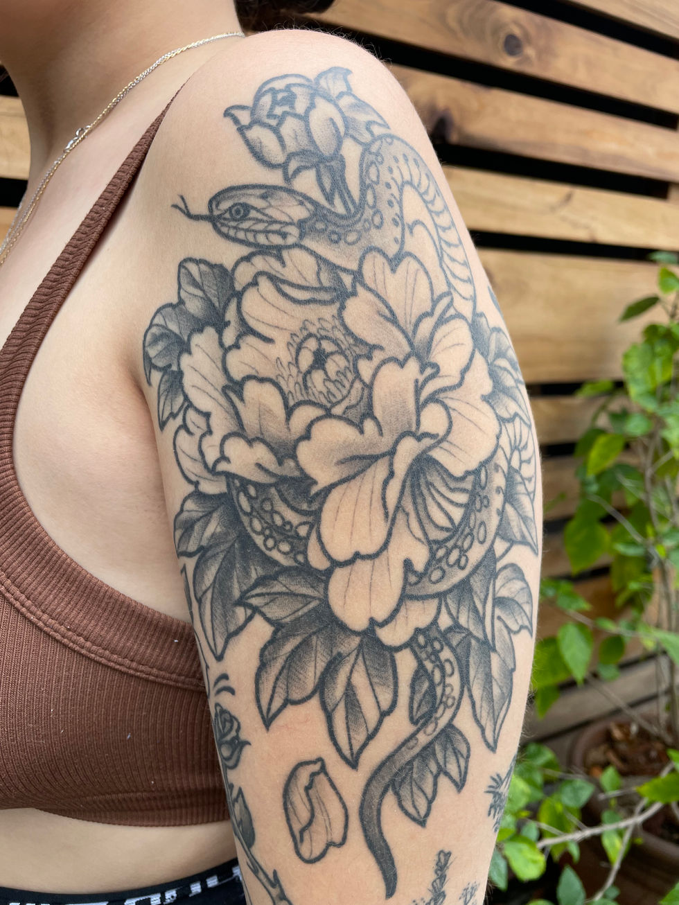 a woman has a tattoo of a snake and a flower on her arm