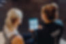 Coach und Kundin gucken auf Tablet