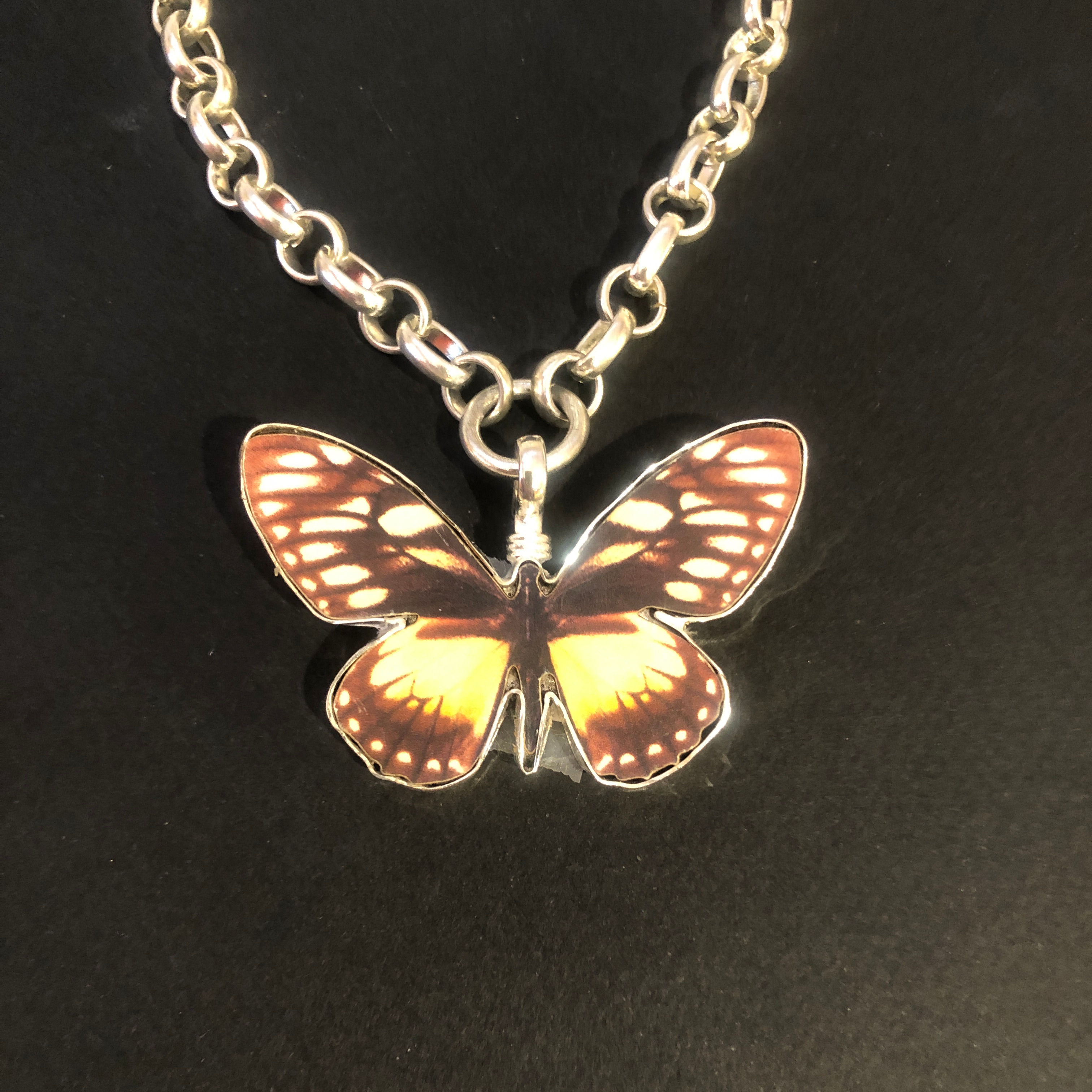 A 2.25 inch painted wood butterfly charm by Coreen Cordova Jewelry