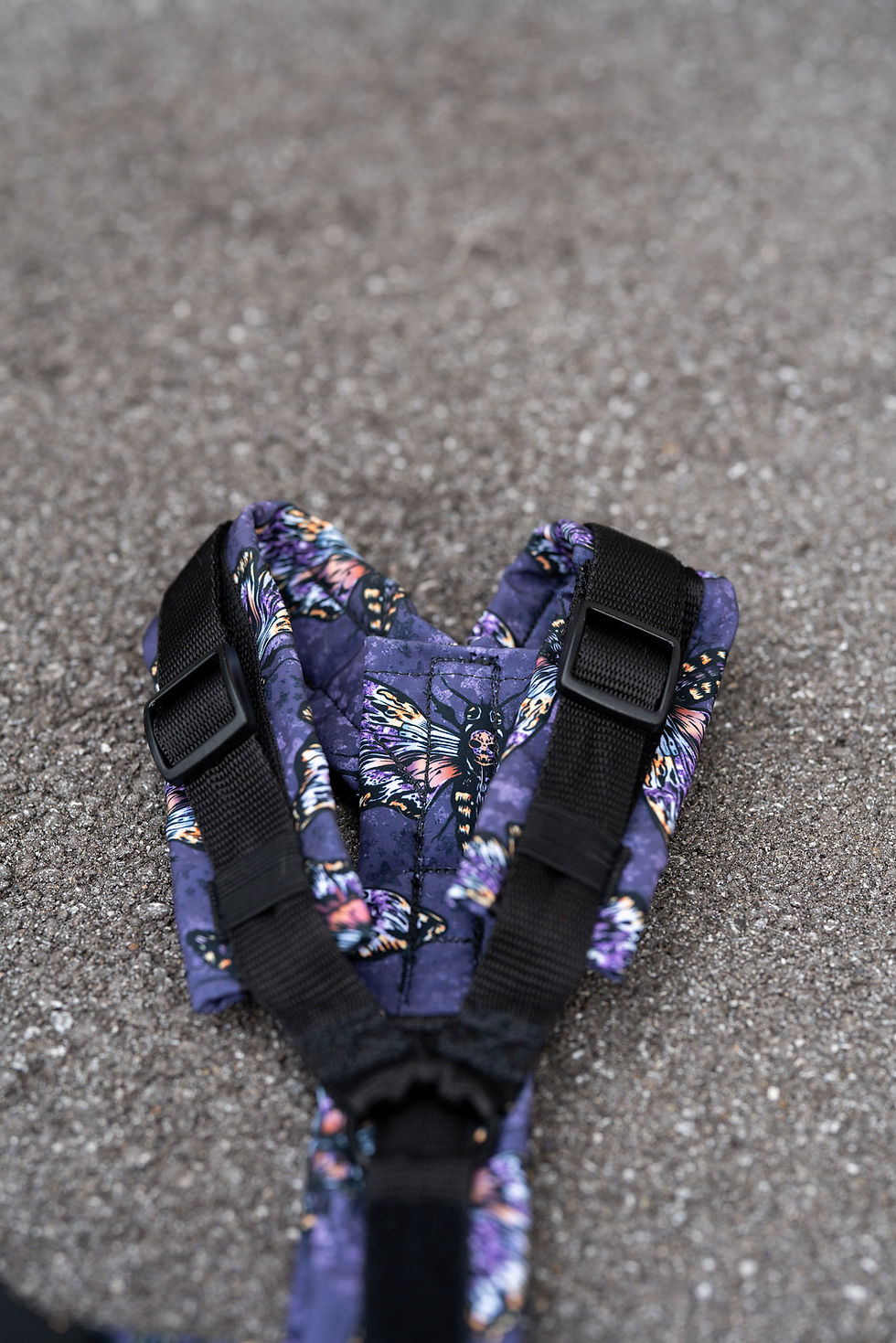 Miniature : Blaues Design mit schwarzen Trägern auf grauem Untergrund und floralem Muster.
