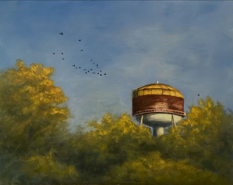 An older watertower sits among treetops with birds flying by.