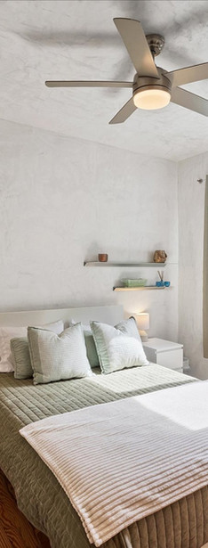 Bedroom with bed and window. Wooden floor and white walls. Home decor.
