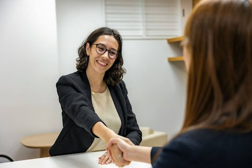 Two women shaking hands in an office