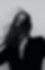 Woman's face partially hidden by windblown dark hair