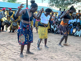 Three women dancing in the middle of a crowd