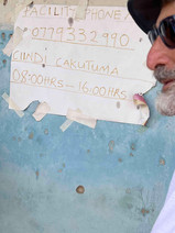 Dominique in front of a ripped paper sign indicating the opening hours