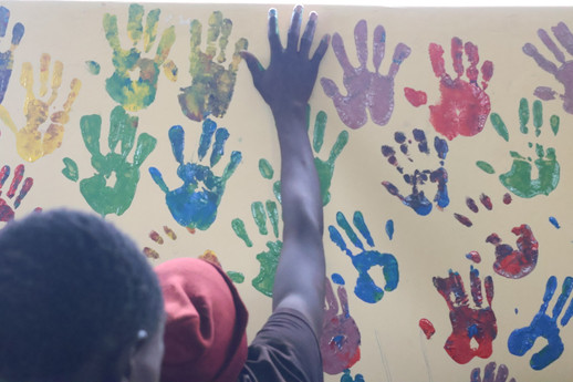 Youth ambassadors mark he walls on the inside with colorful hand imprints