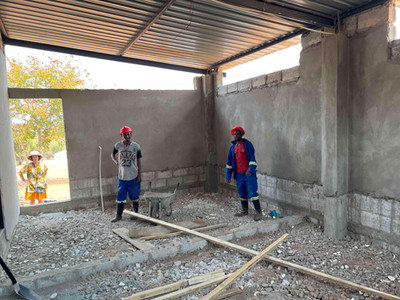 Construction workers inside the Simonga Youth Corner laying the floor stones