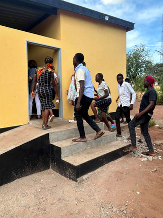 Boyd and other young Zambians walking up the three steps to the entrance of the Youth Corner in Simonga