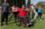 Image of a group of people engaged in an outdoor exercise class, one participant in a wheelchair