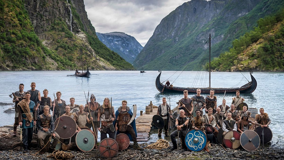 Norwegische Fußballnationalmannschaft in eindrucksvoller Wikinger-Montur vor majestätischer Fjordlandschaft, bereit für ein historisches Abenteuer.